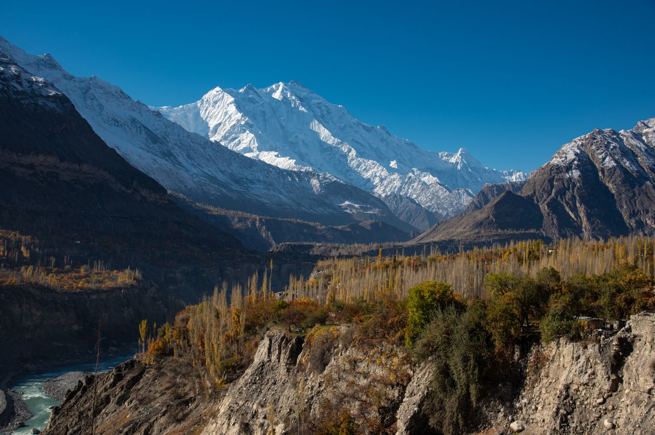 expertise-01 Discover the scenic Hunza Valley with snow-capped mountains and autumn foliage.